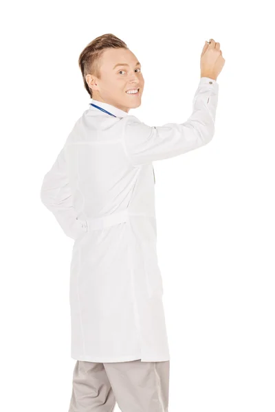 Young  male doctor in white coat writing on blank glass board or — Stok fotoğraf