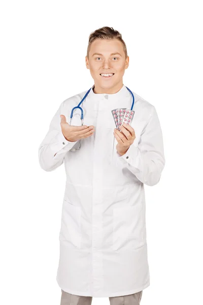 Doctor masculino en manos blancas del abrigo que muestra las píldoras blancas. — Foto de Stock