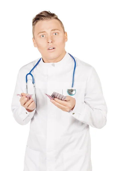 Doctor masculino en manos blancas del abrigo que muestra las píldoras blancas. — Foto de Stock