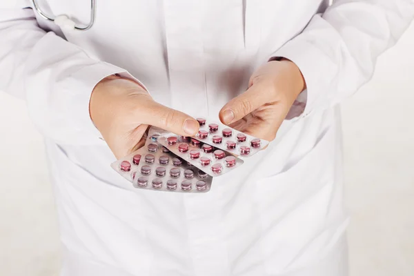 Male doctor in white coat hands showing  white pills .People and — Stock Photo, Image