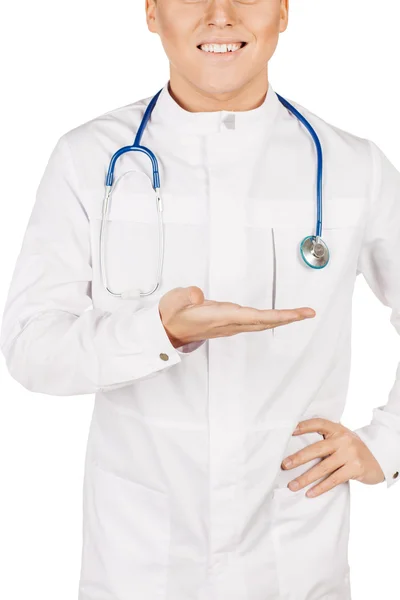 Medical doctor in white coat with stethoscope holding something — 스톡 사진