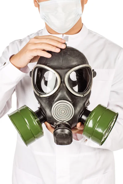 Médecin en manteau blanc avec stéthoscope tenant un masque à gaz. — Photo