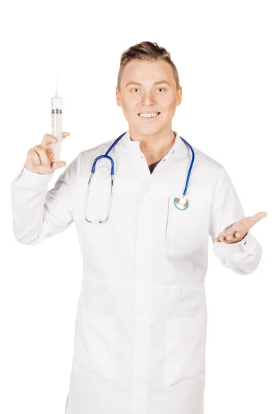 Young male doctor in white coat and stethoscope holding syringe. — Stock fotografie