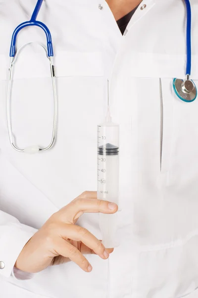 Young male doctor in white coat and stethoscope holding syringe. — Stock Fotó
