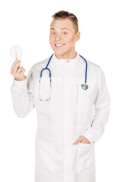 Young male doctor in white coat and stethoscope holding light bu — Stock fotografie