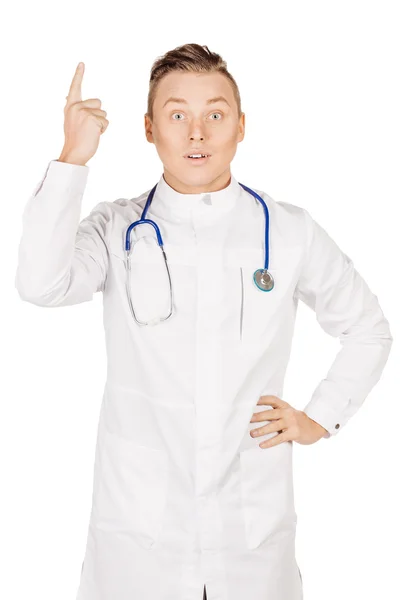 Jeune médecin masculin en manteau blanc et stéthoscope doigt pointe vers le haut — Photo