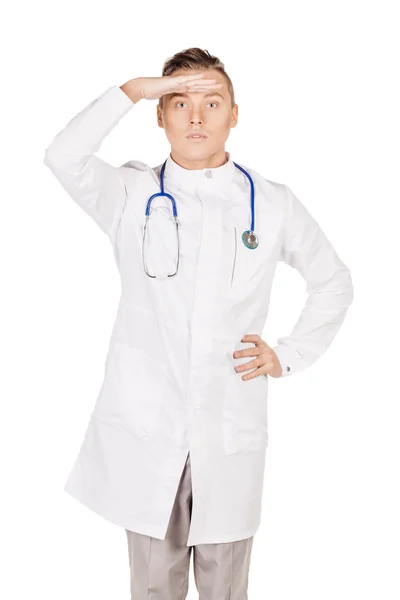 Joven médico masculino en bata blanca mirando hacia otro lado mientras mantiene su h —  Fotos de Stock