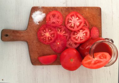 Taze sebzeler, kırmızı domates, masada meyve suyu, domates suyu, portakal suyu, maydanoz, otlar, salata, yeşil domatesler tabakta, domatesler beyaz arka planda..