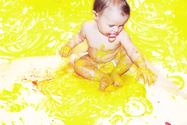 A criança bebê desenha com pinturas coloridas mãos, pés sujos. Brincar com tintas. Foco seletivo. manchado de tinta. criatividade das crianças — Fotografia de Stock