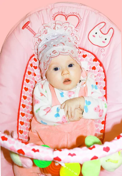 Leuk klein meisje met een roze hoed. Portret mooi in een roze schommel — Stockfoto