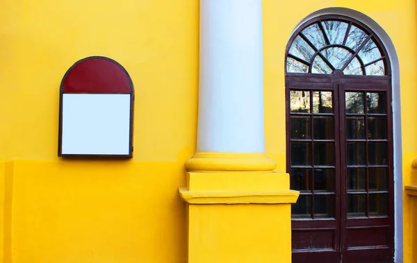 Edifício amarelo Vista da rua para a parede. Fachada amarela de uma casa com uma porta de vidro com uma coluna. Arquitetura antiga, histórica — Fotografia de Stock