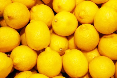Limon, portakal, arka plan olarak taze meyve karışımı, üst manzara. Taze narenciye pazarı. Tahta bir masanın üstünde duran portakal yığını. 