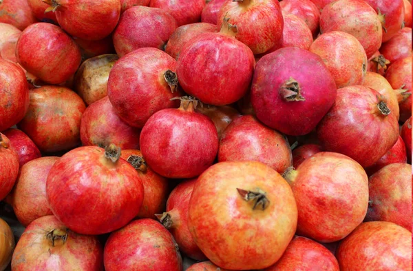 Modello di fondo di melograno frutta. Melograno intero con fiore. Fresco melograno biologico crudo fondo texture cumulo di frutta. Rubino melograno naturale primo piano vista dall'alto. sul mercato — Foto Stock