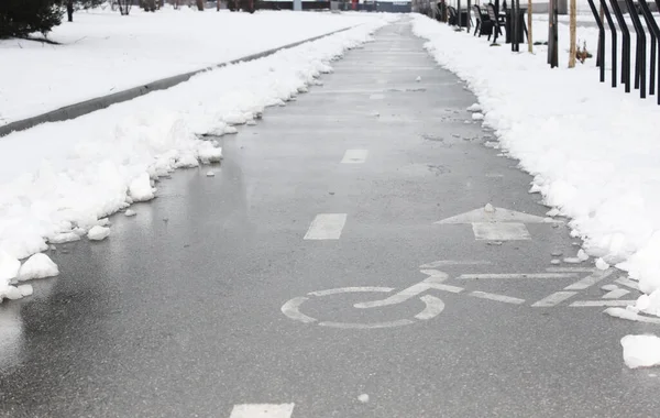 Pista ciclabile nella neve. andare in bicicletta in inverno. piccole lastre di pavimentazione coperte di neve, situate all'esterno, strada dopo le nevicate, marciapiede sotto la neve. Prima neve. Bell'inverno — Foto Stock