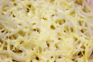 Makarna, pembe bir kasede makarna, beyaz peynirli eski ve eski bir ahşap masa. Akşam yemeği için hazırlanmış peynirli bir tabak lezzetli makarna. Yaklaştın. Fotokopi alanı. yatay