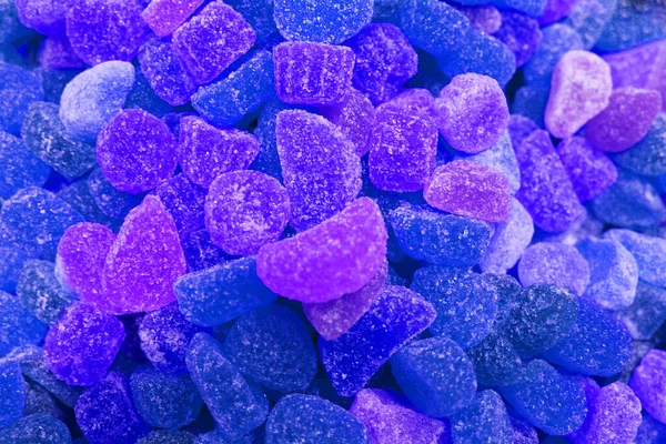 Arkaplan olarak renkli doku kullanılıyor. Bir sürü tatlı. Arkaplan 3D çizimi. Portakal ve siyah pudra şekerli çoklu jöle şekeri. Şekerleme duvar kağıdı konsepti. Boşluğu kopyala