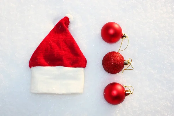 산타 클로스 모자와 크리스마스용 공, 크리스마스 장난감, 공, 하얀 백설 배경 메리 크리스마스 테마의 장식등이 있다. 눈 속에서 부드러운 보트를 타고 — 스톡 사진