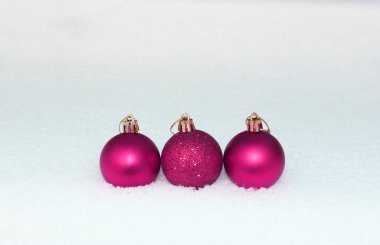 Renkli Noel baloları, Noel oyuncakları, balolar, beyaz karlı arka planda süslemeler... Mutlu Noel temalı kış tatilleri. Nazik bir boke ile karda. Yakın plan. Anlaşıldı.