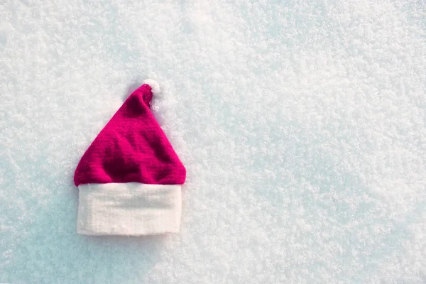 Kırmızı Noel Baba şapkası ve örgü eldivenler karda yatıyor. Eldiven kışın karda yatıyor. Tatil Dekorasyonları Noel ve Yeni Yıl Gelenekleri Panoramik Afiş Boş Alan Yazısı Üst Metin Görünümü