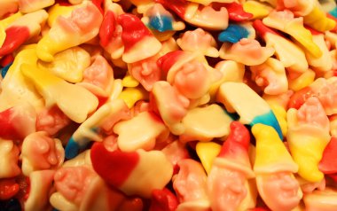 Arkaplan olarak renkli doku kullanılıyor. Bir sürü tatlı. Arkaplan 3D çizimi. Portakal ve siyah pudra şekerli çoklu jöle şekeri. Şekerleme duvar kağıdı konsepti. Boşluğu kopyala