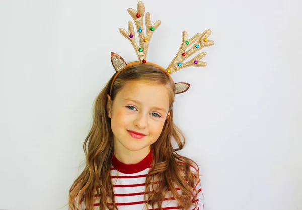 Linda menina veado Papai Noel, em uma camisola vermelha para o Natal e Ano Novo presente. Tenha uma menina feliz em um banner de fundo branco. Menina se alegra e espera por presentes — Fotografia de Stock