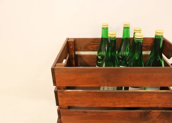 Botellas de vino en una caja de cerca. Caja con botellas de bebida en una caja de madera sobre un fondo de madera blanco. Con espacio para copias. Fondo del vino. El concepto de la fiesta, fiesta, celebración. tienda de bebidas —  Fotos de Stock