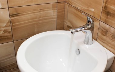Umumi tuvalet lavabosunun içi lavabo ve muslukla dolu. Modern banyo köşesi. Evin içi, dairedeki modern banyo..