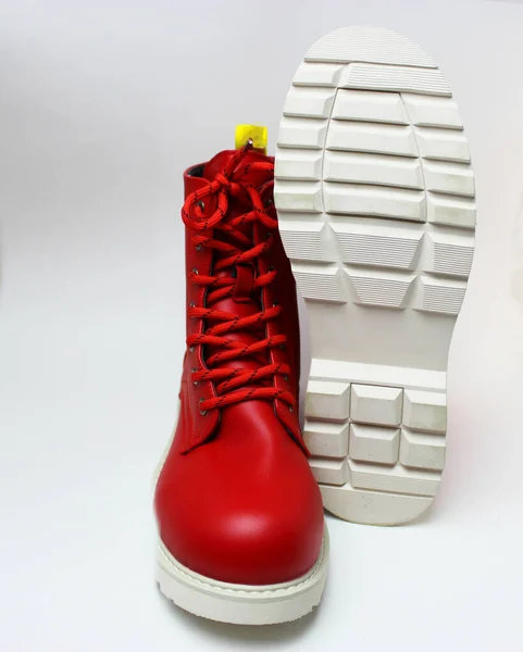 Elegant red womens shoes with laces and white soles isolated on a white background. Red mens boots