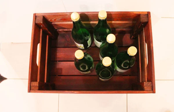 Wine bottles in a box close up. Box with bottles of drink in a wooden box on a white wooden background. With copy space. Wine background. The concept of the holiday, feast, celebration. drinks shop