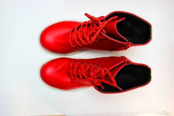 Elegant red womens shoes with laces and white soles isolated on a white background. Red mens boots