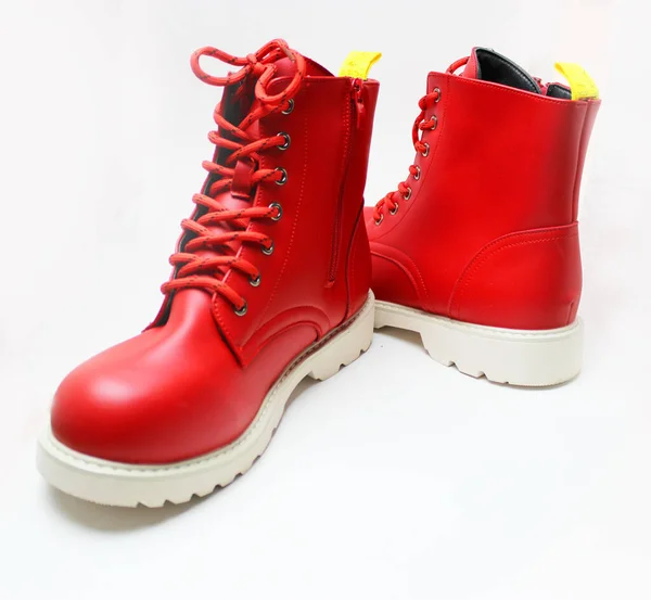Elegant red womens shoes with laces and white soles isolated on a white background. Red mens boots