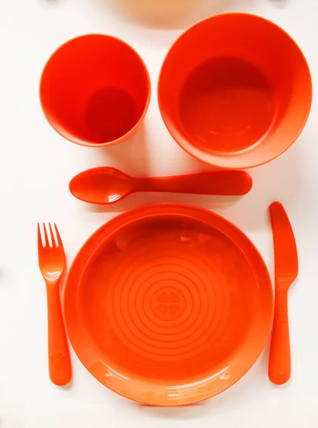 Empty white plastic plate, cup, fork and spoon over white background with copy space. Dining set of plastic cutlery on white Flat lay. and a place for food objects. plastic plates and glasses of — Stock Photo, Image