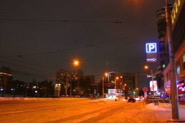 Geceleri fenerlerle aydınlatılan karanlık gökyüzü okunun üzerinde neon ışığı. Kışın gece sokağı