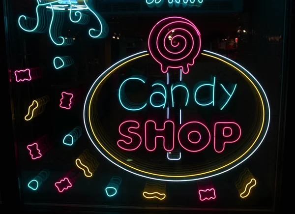 Neonbuchstaben Candy shop mit neonbeleuchtung auf dem glas, das konzept eines cafés und kaffee, und süßigkeiten Leuchtende neonschrift und stilisiert,. Vintage-Image in dunklen Tönen. — Stockfoto