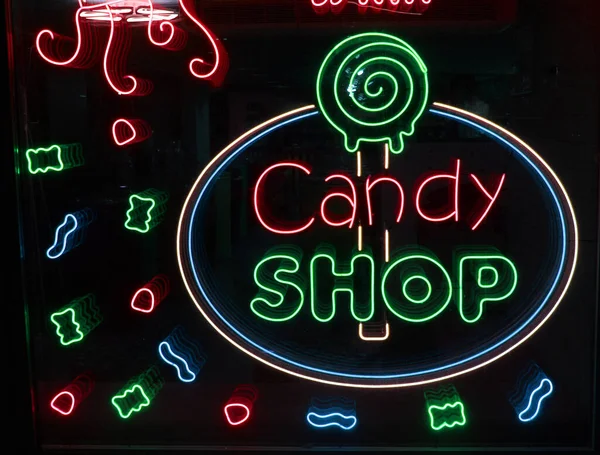 Neonbuchstaben Candy shop mit neonbeleuchtung auf dem glas, das konzept eines cafés und kaffee, und süßigkeiten Leuchtende neonschrift und stilisiert,. Vintage-Image in dunklen Tönen. — Stockfoto