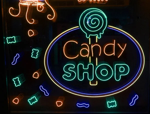 Neonbuchstaben Candy shop mit neonbeleuchtung auf dem glas, das konzept eines cafés und kaffee, und süßigkeiten Leuchtende neonschrift und stilisiert,. Vintage-Image in dunklen Tönen. — Stockfoto