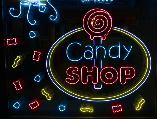 Neonbuchstaben Candy shop mit neonbeleuchtung auf dem glas, das konzept eines cafés und kaffee, und süßigkeiten Leuchtende neonschrift und stilisiert,. Vintage-Image in dunklen Tönen. Stockbild