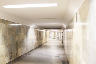 Uzakta uzun ve boş bir tünel var. Bir istasyondan diğerine yaya geçidi, duvarlar hafif mermerden yapılmış. İnsansız metro tüneli. Toplu taşıma