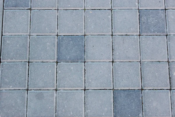 Beton oder Kopfsteinpflaster grau quadratische Pflasterplatten oder Steine für Boden, Wand oder Weg. Traditioneller Zaun, Hof, Hinterhof oder Straßenpflaster. — Stockfoto