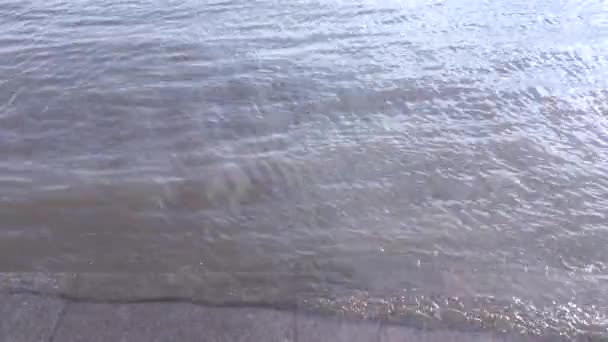 Le onde corrono e vengono lavate dai gradini del terrapieno in granito. ... Passi del argine del fiume con onde lentamente ondulate. Al rallentatore. I gradini di granito del terrapieno sono lavati dalle onde — Video Stock