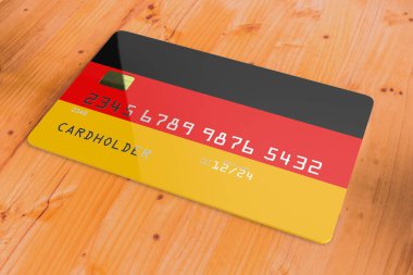 Almanya 'nın bayrağını taşıyan plastik kredi veya banka kartı. Ulusal bankacılık sistemi ahşap masaya izole edilmiş. Kapanış konsepti 3D görüntüleme