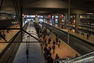 Madrid 'deki RENFE banliyö trenlerinin Atocha istasyonundaki kalabalık, Coronavirus salgınından dolayı günlük yolculuklarını yapıyor, maske takarak yürüyen merdivenleri tırmanıyor.