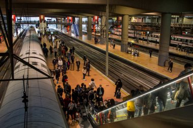 Madrid 'deki RENFE banliyö trenlerinin Atocha istasyonundaki kalabalık, Coronavirus salgınından dolayı günlük yolculuklarını yapıyor, maske takarak yürüyen merdivenleri tırmanıyor.
