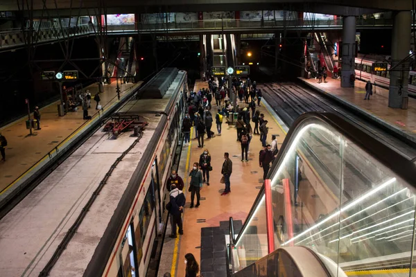 Madrid 'deki RENFE banliyö trenlerinin Atocha istasyonundaki kalabalık, Coronavirus salgınından dolayı günlük yolculuklarını yapıyor, maske takarak yürüyen merdivenleri tırmanıyor.