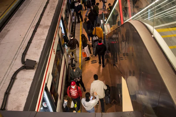 Madrid 'deki RENFE banliyö trenlerinin Atocha istasyonundaki kalabalık, Coronavirus salgınından dolayı günlük yolculuklarını yapıyor, maske takarak yürüyen merdivenleri tırmanıyor.