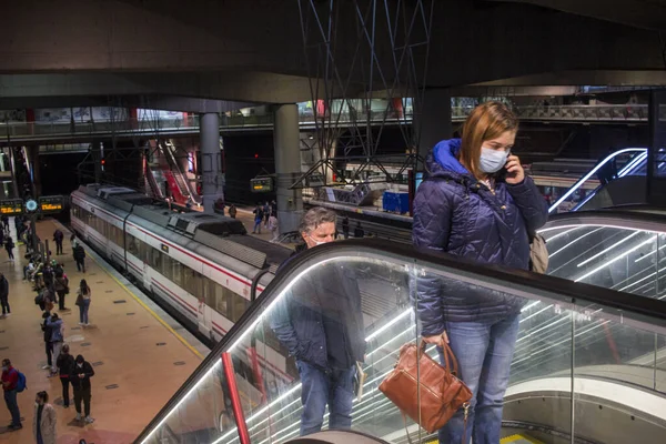 Madrid 'deki RENFE banliyö trenlerinin Atocha istasyonundaki kalabalık, Coronavirus salgınından dolayı günlük yolculuklarını yapıyor, maske takarak yürüyen merdivenleri tırmanıyor.