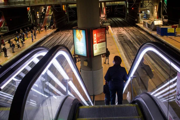 Madrid 'deki RENFE banliyö trenlerinin Atocha istasyonundaki kalabalık, Coronavirus salgınından dolayı günlük yolculuklarını yapıyor, maske takarak yürüyen merdivenleri tırmanıyor.