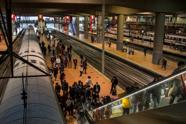 Madrid 'deki RENFE banliyö trenlerinin Atocha istasyonundaki kalabalık, Coronavirus salgınından dolayı günlük yolculuklarını yapıyor, maske takarak yürüyen merdivenleri tırmanıyor.
