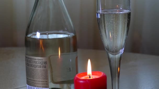 Vinho espumante branco e ao lado de uma vela vermelha — Vídeo de Stock