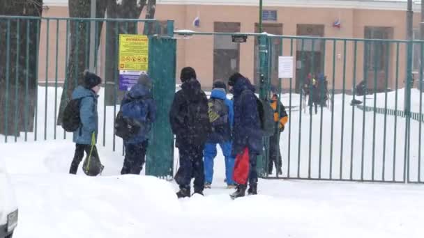 Школьники после зимних занятий, снег — стоковое видео